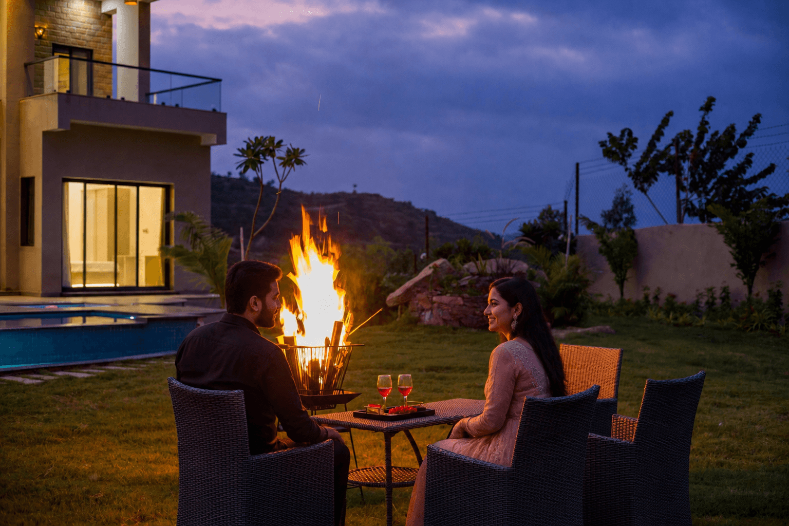 Couple enjoying a bonfire evening at a Book My Villas property